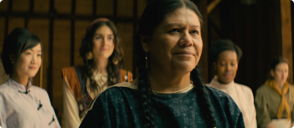 Photo of a weaver standing at the front with and a group of four seamstresses behind her